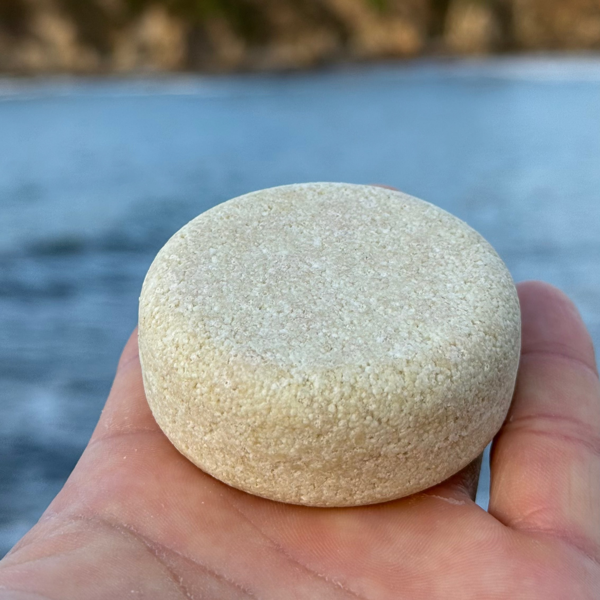 sosteniendo el champu de cabellos secos de amodinho cosmetica natural