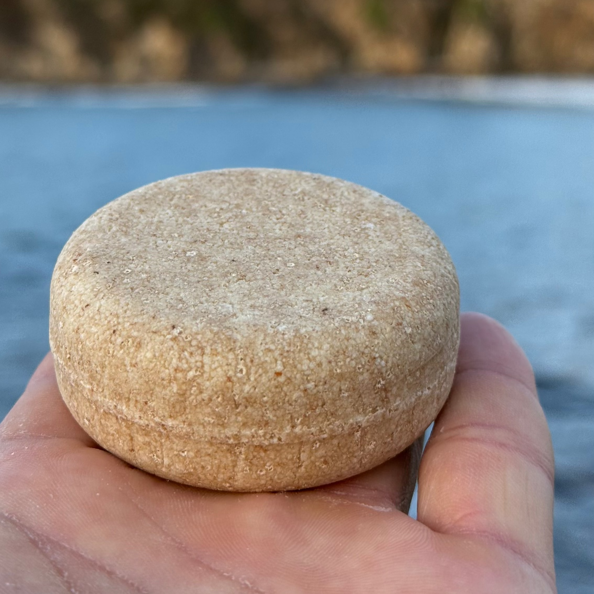 sosteniendo el champu para cabellos grasos de amodinho cosmetica natural